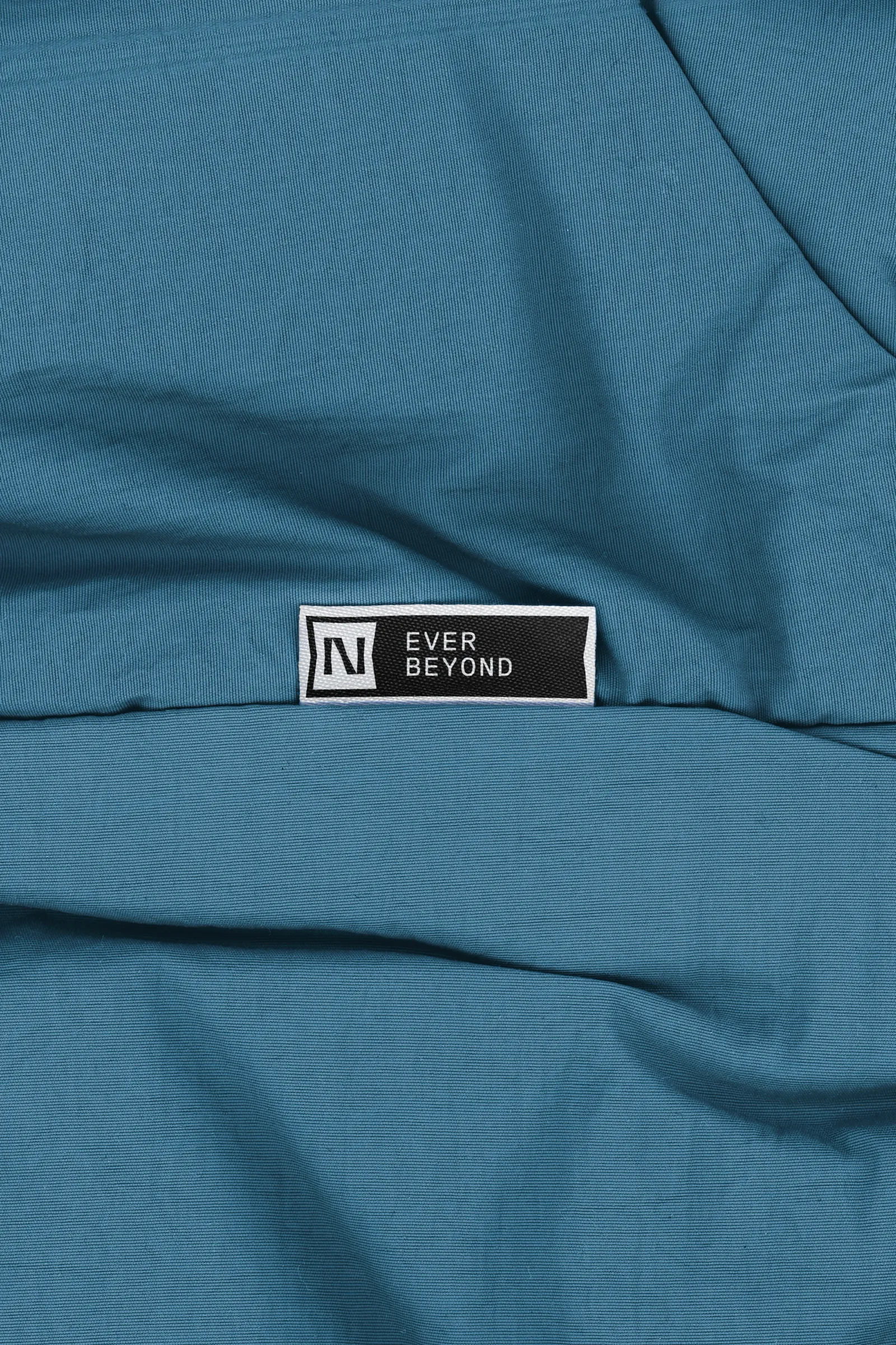 Étiquette tissée Ninety-Nine cousue sur un textile bleu