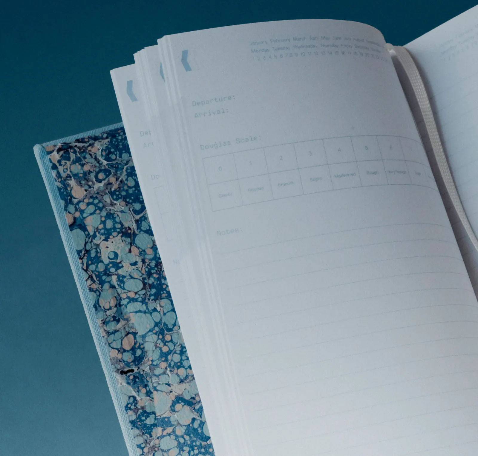 Logbook Ninety-Nine ouvert sur sa pochette en papier marbré