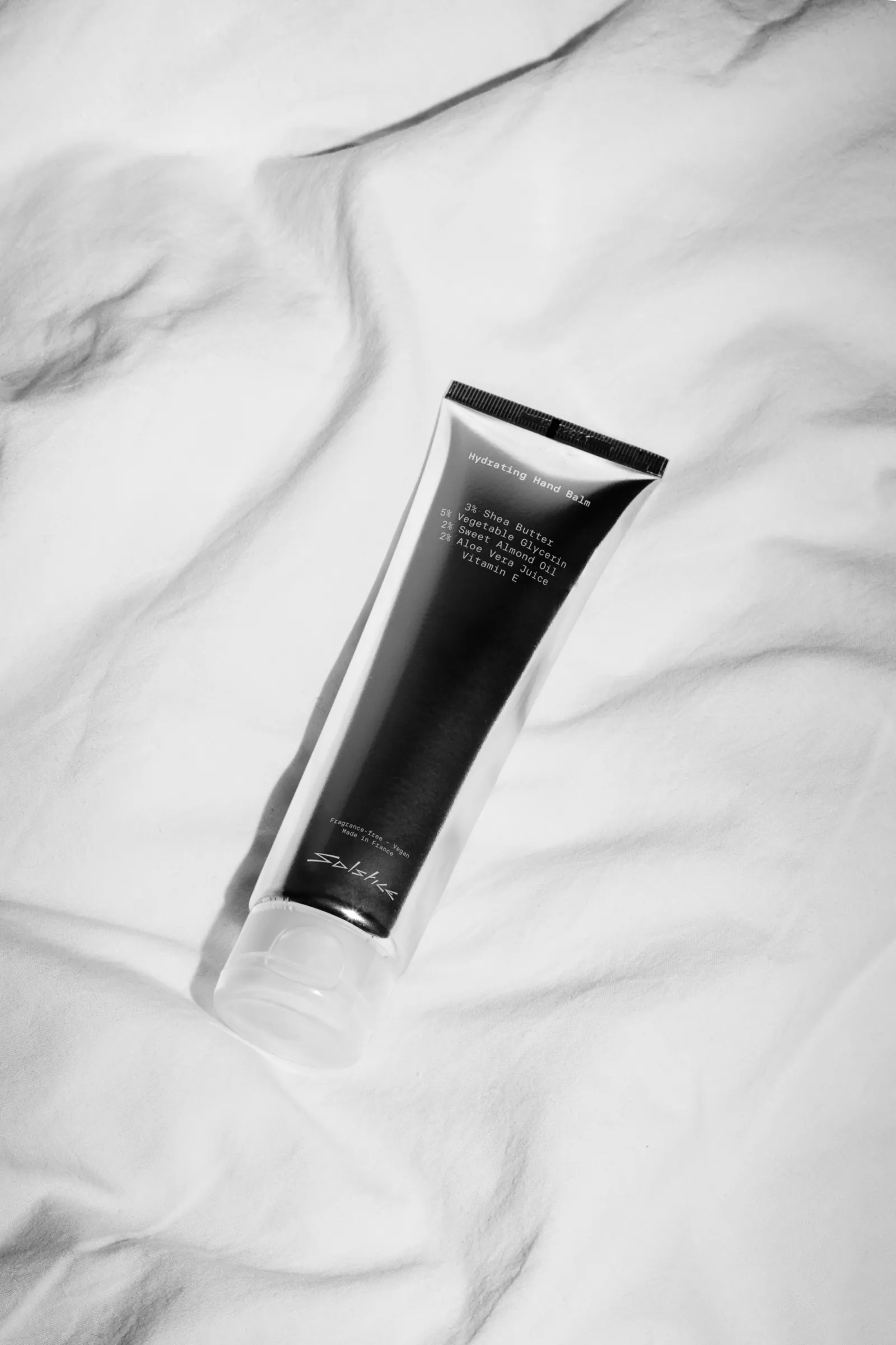 Tube de crème noir Solstice sur un drap blanc